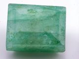 a close up of a green emerald stone on a white surface