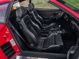the interior of a red sports car with black leather seats