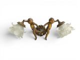 three bronze figurines of women with flowers on a white background