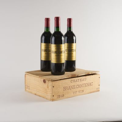 trois bouteilles de vin rouge dans une caisse en bois sur fond blanc