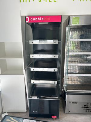 une vitrine au milieu d'une pièce où de nombreux objets sont éparpillés sur le sol