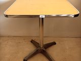 une petite table avec un piètement en métal et un plateau en bois