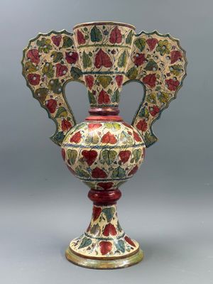 a vase with a floral design on it sitting on a table