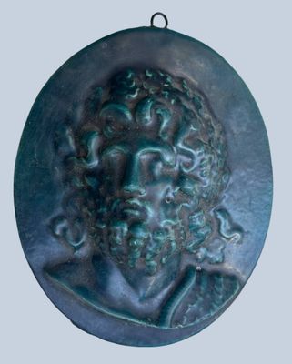 a close up of a bronze medallion of a man with curly hair