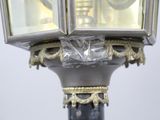 a close up of a lamp post with a clock on top of it