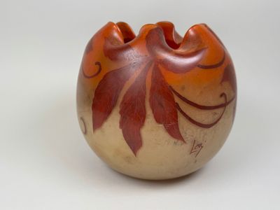 un petit vase avec un motif sur une surface blanche