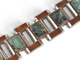 a close up of a bracelet with green stones on it