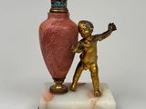 a statue of a boy holding a vase on a marble base