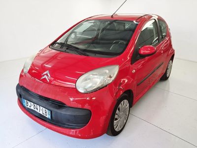une voiture rouge garée dans une pièce blanche