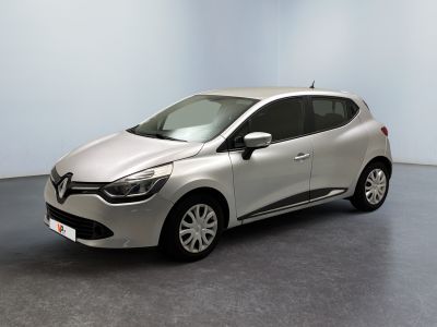 La voiture argentée est garée dans une pièce au sol gris.