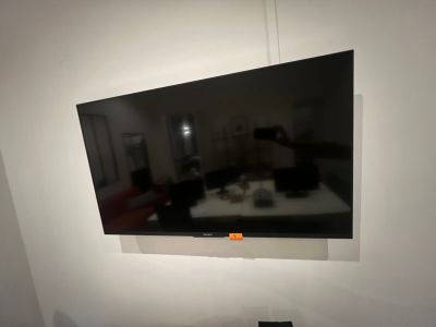 a flat screen tv mounted on the wall above a bed