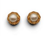 une paire de boucles d'oreilles en or et perles sur fond blanc