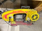 une machine jaune et rouge posée par terre