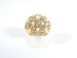 a close up of a ring with pearls and diamonds on a white surface