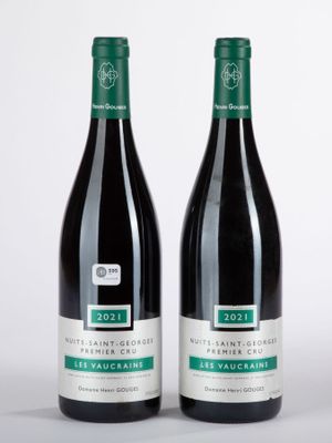 deux bouteilles de vin posées l'une à côté de l'autre sur une surface blanche