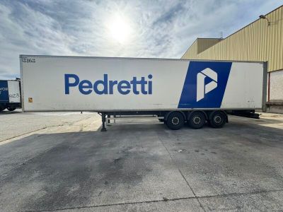 un gros plan d'une semi-remorque garée devant un immeuble