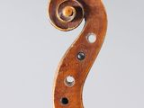 a close up of the back of a violin with a fiddle in the foreground