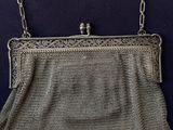 an antique silver mesh purse with a chain strap and clasp