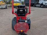 a close up of a red riding mower in a parking lot