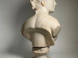 a white marble bust of a woman with a braided hair