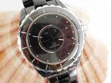 a black watch on a black bracelet with a shell in the background