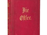 a red book with gold lettering sitting on top of a white surface