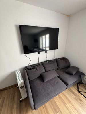 un salon avec un canapé et une télévision à écran plat accrochée au mur