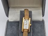 une photo d'une montre dans un coffret, avec une étiquette de prix dessus