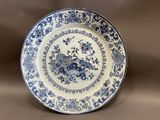 an old blue and white plate with flowers and birds on it