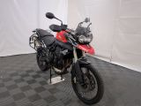 une photo d'une moto rouge et noire garée dans un garage