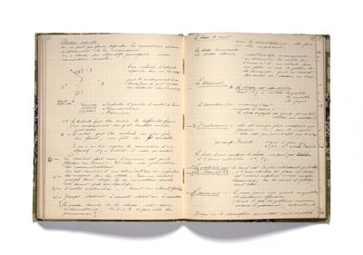 an open book with writing on it sitting on top of a white surface