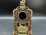 une image représentant une petite horloge ancienne posée sur une table, sur fond noir