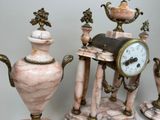 three different types of vases and a clock on a table