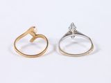 two gold and silver rings on a white surface