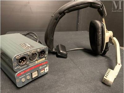 un casque posé sur une table, à côté d'un micro et d'un autre casque