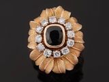 a close up of a ring with a black stone surrounded by white diamonds