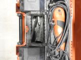 un étui orange contenant un cordon et un outil