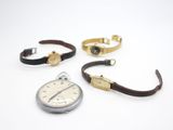 trois types différents de montres-bracelets et une montre posée sur un fond blanc
