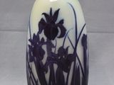 un vase blanc orné de fleurs violettes, posé sur une table