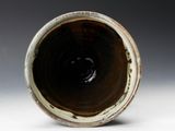 a close up of a brown and white vase