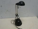 une lampe noire posée sur une table blanche