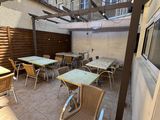 tables and chairs on the patio of a building
