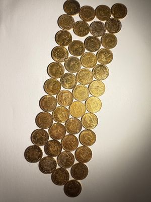 une pile de pièces d'or posée sur une surface blanche