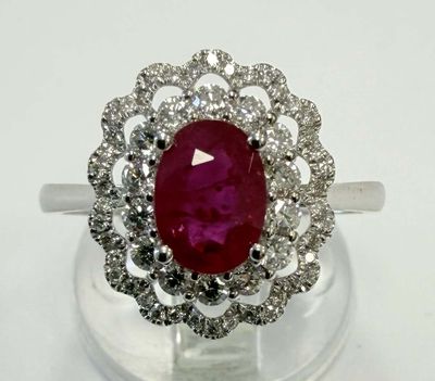 gros plan d'une bague avec une pierre rouge entourée de diamants blancs