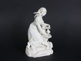 a white statue of a woman sitting on a rock holding a pot