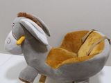 stuffed donkey on a wooden sleigh with wheels on a white surface