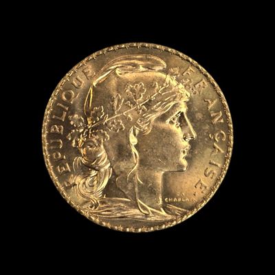 Gros plan sur une pièce d'or ornée d'une tête de femme