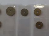 several different types of coins are displayed on a white surface