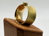 a gold ring sitting on top of a wooden block