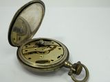 a pocket watch that is sitting on a white surface